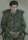 A young man in khaki sitting in a chair with his hands clasped in his lap.