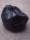 A bronze sculpture painted hyper-realistically to resemble a full black bag of rubbish