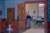 A painting by Harold Gilman of a domestic interior scene in which is landlady Mrs Mounter stands in the doorway through to the kitchen.
