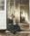 A woman sits on a step outside an open door, engrossed in a book open on her lap.