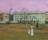 Painting by Walter Sickert showing a people promenading in front of a white building under a pink-purple sky