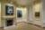 Interior of a Queen Anne townhouse with period fittings including a fireplace. An abstract portrait by Sidney Nolan hangs above the fireplace and two other paintings by the artist hang on hall to the right.