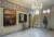 Interior of a Queen Anne townhouse with period fittings and two landscape paintings by Sidney Nolan hanging on the left side. To the right stands a home made set of armour produced for the 1970 Ned Kelly film.