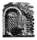 Black and white wood engraving of a tortoise in front of a brick archway covered in ivy.