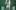 Painting depicting Jesus hanging on the cross, his head bowed and with an emaciated torso against a green background