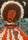 A woman with a heavily lined face and afro hairstyle wearing a patterned cloak with a heart pattern over her chest. The woman is rencdere din bunrt orange and brown. The top half of the background is a dark sky with crescent moon in the top right corner. The bottom hald of the background shows a geometric patter in blue, white and dark brown.