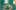 Green coloured room with open doorway to right and in the middle a small yacht with a white flapping sail and around it discarded benches