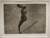 Print in black and white of a woman without arms descending a small staircase
