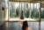 Interior of a room looking through large windows with cone like sculpture outside and inside