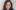 Photograph of woman with long wavy dark hair from shoulders up