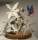 Photograph of a clay floral sculpture on a wooden base