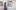 Woman walking from left blurred past a painting on the wall of an open white door in a surreal landscape